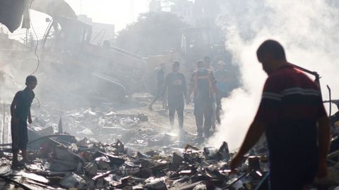 Bomberos palestinos trabajan entre las ruinas de un edificio en Gaza.