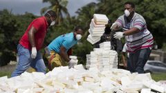 Varios operarios lanzan fardos de coca�na y hero�na para ser incinerada. 