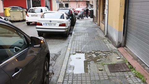 Acera en mal estado ante un garaje del barrio