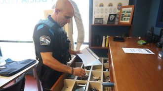 Un agente de la Polic�a Local eumesa revisa uno de los cajones donde guardan los objetos perdidos