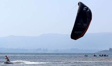 Uno de los monitores demuestra c�mo se cabalga sobre el agua con una cometa bajo la at�nita mirada de las mariscadoras.