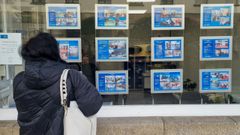 Una compostelana ojea los precios de varias viviendas ubicadas en la ciudad