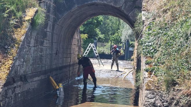 Bomberos achicando agua tras las lluvias torrenciales del pasado mes de junio, en Arcos (Vilamart�n de Valdeorras).