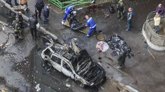 Operarios recogen el cuerpo del teniente general ruso Yaroslav Moskalik, al lado del coche bomba.