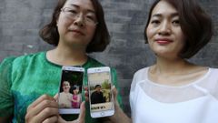 Wang Qiaoling (i) y Li Wenzu muestran las fotograf�as de sus respectivos maridos, los abogados de derechos humanos Li Heping y Wang Quangzhang, en una foto de archivo.