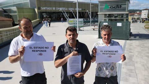 Jesús Domínguez, portavoz de la Plataforma del Alvia (centro), junto a otros miembros del colectivo, frente a la estación de tren de Santiago