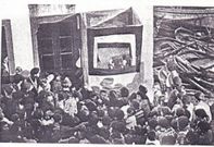 20 de outubro de 1933. Colecci�n L. Hern�ndez Iglesias. Representaci�n do Teatro de t�teres na praza principal de Malpica, fronte � casa de Ram�n da Perilla, �Casa da Santa� coa �Rampla de don Anselmo Villar Amigo�, � dereita, varadeiro de embarcaci�ns de vela e remo mari�eiras. Est�n identificados varios veci�os, entre eles, Consuelo Gra�a, �Consuelo do Cura� (abaixo esquerda), e Antonio Otero Casti�eiras (neno do medio).