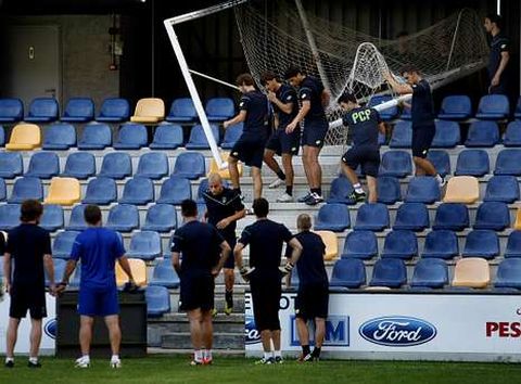 Varios de los jugadores cargan con una porter�a antes de empezar el entrenamiento de ayer.