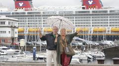 Dos cruceristas del buque Disney Dream, ayer bajo la lluvia en el paseo de la Marina