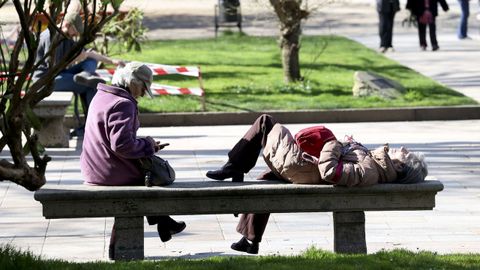 Dos mujeres disfrutando del sol en un banco de Santiago.