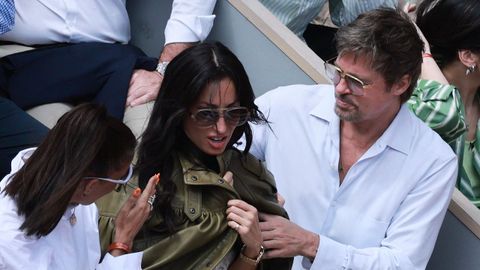 Brad Pitt ayuda a su novia, la espa�ola In�s de Ram�n, a colocarse la chaqueta durante el partido en Roland Garros.