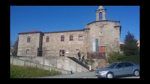 El iglesario de Agrela, casi oculto por las industrias que lo rodean, mantiene dos siglos de función social