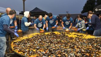 El equipo organizador sirve la gran paella en Cortegada 2025.