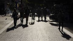 Un grupo de persoas cami�a por unha r�a.