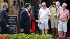 Rajoy, acompa�ado de Barber� y Fabra, pasea por la playa valenciana de la Malvarrosa ante la mirada de un grupo de turistas. 