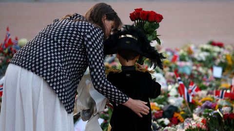 Un ni�o deja un ramo de flores en el exterior del palacio real de Oslo