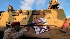 Un combatiente de las fuerzas de Haftar apunta a una imagen de Erdogan colgada de un blindado turco confiscado durante los combates en Trpoli 