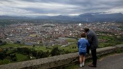 Un abuelo y su nieto miran Oviedo desde el Naranco