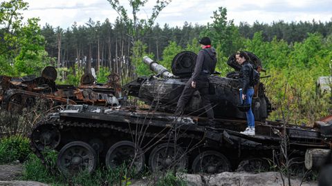 Personas observan un tanque ruso destruido en la aldea de Dmitrivka, cerca de Kiev.