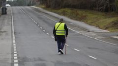 Un peat�n equipado con chaleco reflectante cruza una carretera cerca de Santiago.