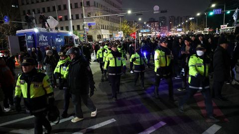 Agentes de polica caminan entre la multitud, despus de que el presidente surcoreano, Yoon Suk Yeol, declarara la ley marcial.