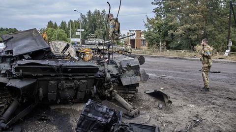 Soldados ucranianos observan los restos de un tanque destruido en la ciudad de Izium.