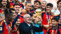El seleccionador nacional Luis de la Fuente muestra el trofeo de campeones del mundo rodeado por sus jugadores.