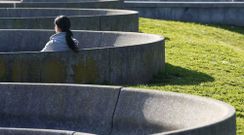 Una mujer sentada al sol en un parque de Oviedo
