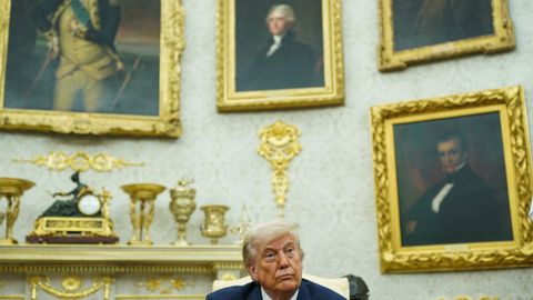 Trump junto a una colección de cuadros con marcos dorados en la Casa Blanca.
