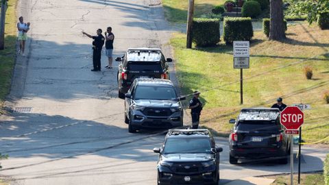 Un miembro de las fuerzas del orden habla con vecinos cerca de la casa de Thomas Matthew Crooks, arrestado por el intento de magnicidio de Trump.