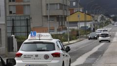 Vehculo de autoescuela haciendo prcticas por una calle de Foz