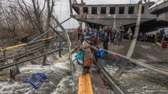 Una mujer es ayudada a atravesar un r�o en la localidad de Irp�n, en la regi�n de Kiev