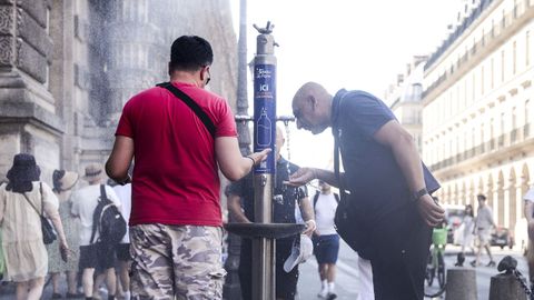 Gente se refresca en una fuente cercana al Louvre en París, Francia