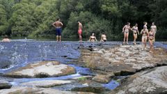 Gente ba��ndose para combatir el calor en la zona O Piago