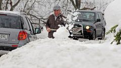 Un vecino del pueblo de Pajares trata de sacar su coche de la nieve
