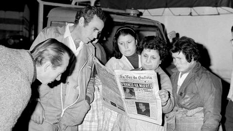 Trabajadores delMuro de A Corua leen a primera hora de la maana la edicin especial de La Voz de Galicia.