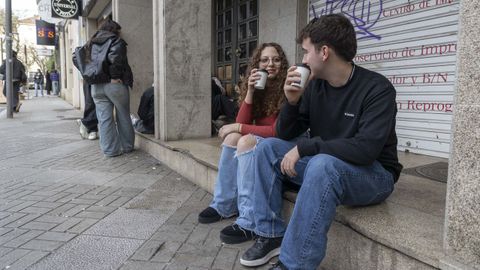 Dos universitarios toman caf en la Ra dos Fens antes de entrar a estudiar.