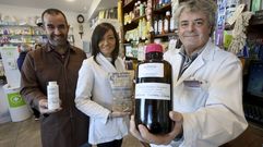 Eduardo Esteban y dos trabajadores de su farmacia, mostrando algunos de los productos que les convierten en un negocio �nico.