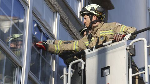 Los bomberos, retirando los trozos que corran riesgo de desprenderse, este domingo por la maana