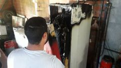 Uno de los residentes del edificio afectado junto a la caldera quemada