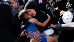 Una mujer sostiene a un niño en el funeral por los muertos en un ataque en Jan Yunis.