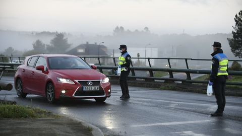 Reparto entrega de mascarillas por la Guardia Civil y Polica Local a trabajadores en la entrada del polgono industrial Lalin 2000