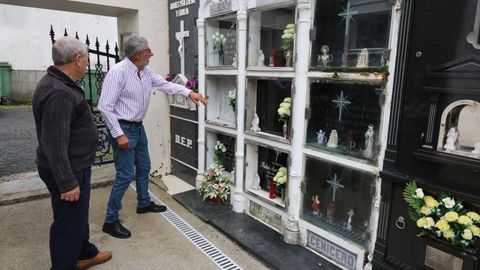 Dos vecinos delante de varios de los nichos en los que destrozaron las puertas de cristal