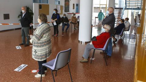 Varios pacientes esperan en el recibidor del auditorio a que les avisen para dirigirse al centro de salud, ayer