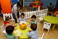 Ni�os haciendo fichas en la ludoteca de Chapela, junto a la directora del centro, Ruth Orge.
