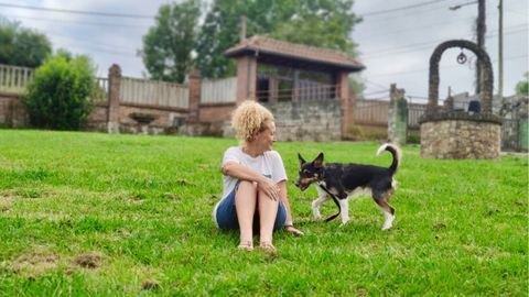 Eva en la finca de la Residencia El Carbayn junto a un perro.