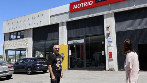 Los empleados posan ante la fachada de la nave del taller