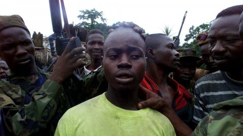 Un rebelde de 18 a�os rodeado por tropas del gobierno despu�s de ser capturado en Sierra Leona.