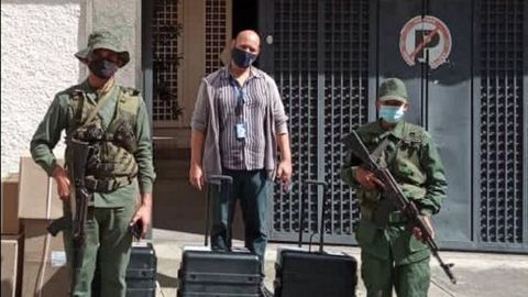Un miembro de la Hermandad Gallega de Caracas, junto a los militares, en el colegio Castelao
