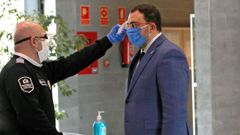 Un miembro de seguridad toma la temperatura al presidente del Gobierno de Asturias, Adri�n Barb�n, durante su visita este s�bado a las instalaciones del Servicio de Emergencias del Principado (Sepa).